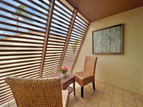 a room with two chairs and a table and a window at Maui Kamaole D208 in Wailea
