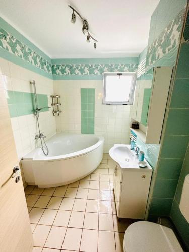 a bathroom with a tub and a toilet and a sink at Apartament lux Albert in Olimp