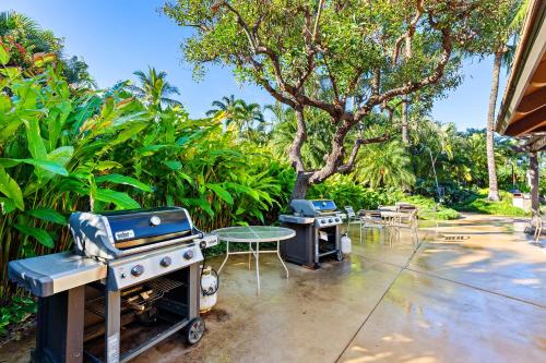 a patio with two bbqs and a grill and tables at Maui Kamaole D208 in Wailea