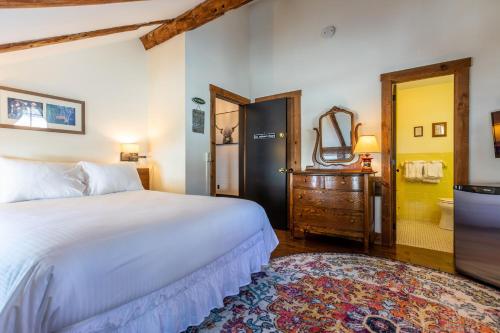 a bedroom with a white bed and a bathroom at The Barnstead Inn in Manchester Center