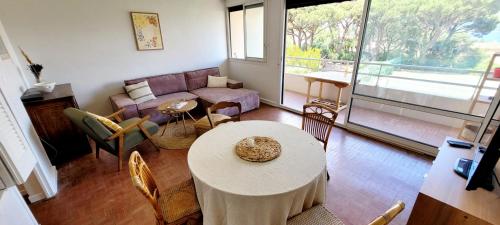 ein Wohnzimmer mit einem Sofa und einem Tisch in der Unterkunft Family nest overlooking the Gulf of Saint-Tropez in Saint-Tropez
