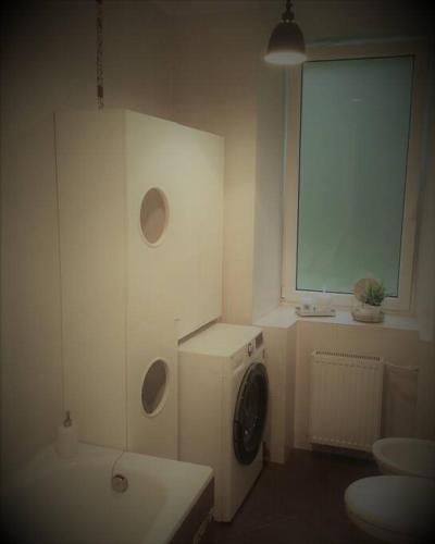 a laundry room with a washing machine and a window at Historic house residence in Vilnius