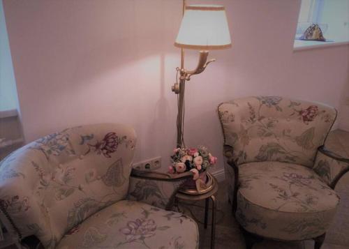 twee stoelen en een lamp in een kamer bij Historic house residence in Vilnius
