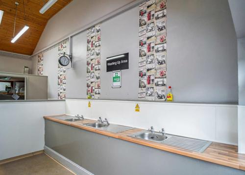 a bathroom with two sinks and pictures on the wall at Lee Valley Sewardstone in Enfield Lock
