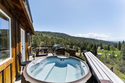 a hot tub on the balcony of a house at Echo Valley Resort + Cabins in Manson