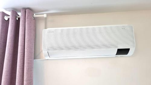 a bathroom with a air conditioner on a wall next to a curtain at Wohnung: Beast. Bis 6 Personen, Klima, Massageliege, 3x TV in Cremlingen