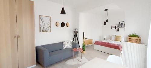 凱奇凱梅特的住宿－Belvárosi Stúdió Apartman，客厅配有蓝色的沙发和床。