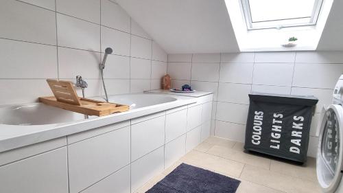 a white bathroom with a sink and a washing machine at Wohnung: Beast. Bis 6 Personen, Klima, Massageliege, 3x TV in Cremlingen