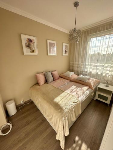 a bedroom with a large bed with pink pillows at Sóstó Forest Apartman in Nyíregyháza