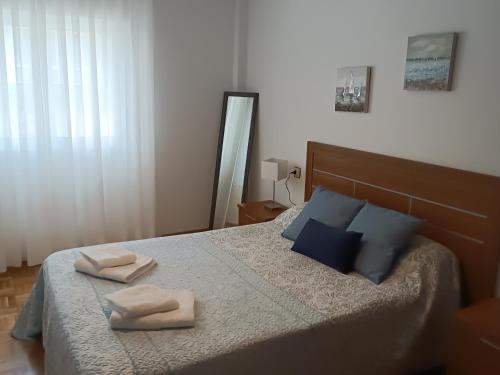 een slaapkamer met een bed met twee handdoeken erop bij Altamar in Llanes