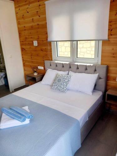 Un dormitorio con una gran cama blanca con ventana. en Divine Studios Elafonisos A2, en Elafonisos