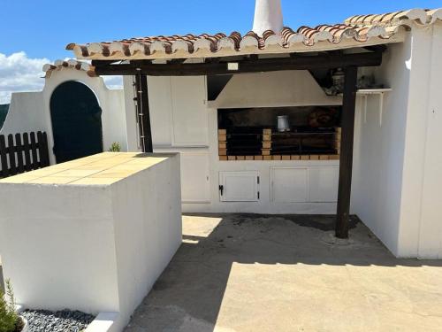 een keuken in een wit gebouw met een dak bij Vivenda Marias in Lagoa