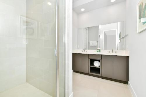 uma casa de banho com um chuveiro e um lavatório. em Stylish Condo near Disney w Hotel Amenities 7770- 26-110 em Kissimmee