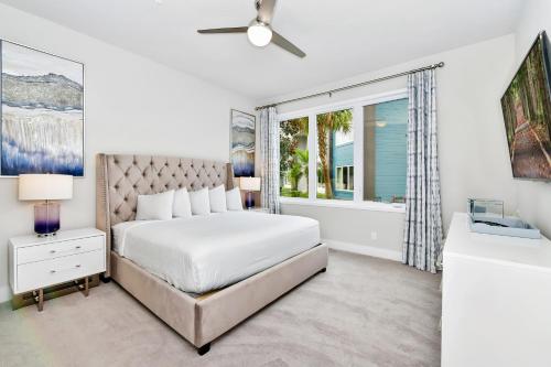 um quarto branco com uma cama e uma janela em Stylish Condo near Disney w Hotel Amenities 7770- 26-110 em Kissimmee