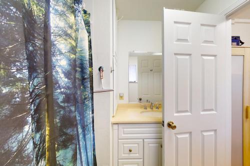 uma casa de banho com um lavatório e uma porta branca em Spruce Overlook em Shelter Cove