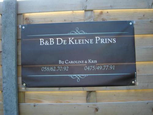 
a sign on a wooden post at B&B De Kleine Prins in Westende
