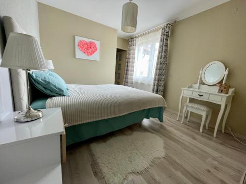 1 dormitorio con cama, mesa y espejo en Cozy Independent guest house, free parking, en Tomaszów Mazowiecki