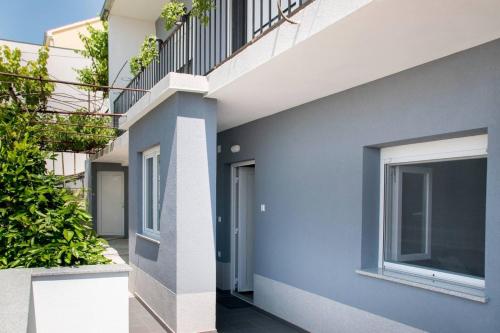 een gevel van een huis met blauwe muren en een trap bij Apartment Bruna in Solin