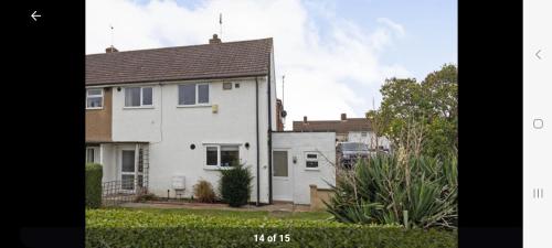 een wit huis met een tuin ervoor bij Home in Cheltenham in Golden Valley