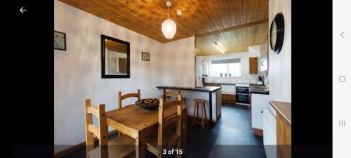 Golden Valley的住宿－Home in Cheltenham，厨房以及带木桌和椅子的用餐室。