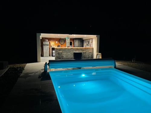 una piscina notturna con luci blu di La Villa cocooning a Changé