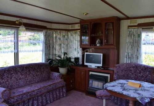 ein Wohnzimmer mit einem Sofa und einem TV in der Unterkunft Domek Holenderski in Mikołajki