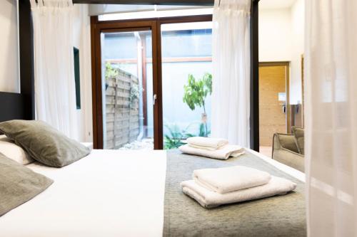 een slaapkamer met een wit bed en handdoeken bij Loft 2 by Basquelidays in Hondarribia