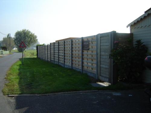a fence next to a road with grass next to it at B&B De Kleine Prins in Middelkerke