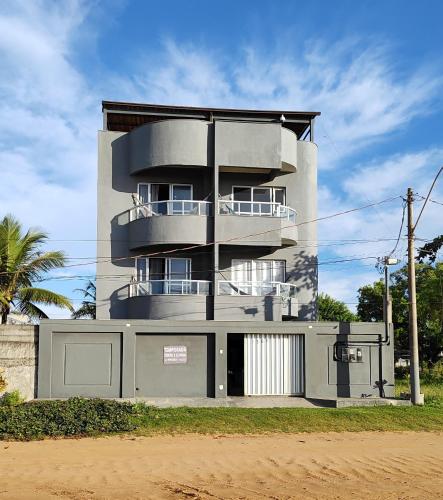 a tall building with a fence in front of it at Bertholi Beira-Mar in Serra