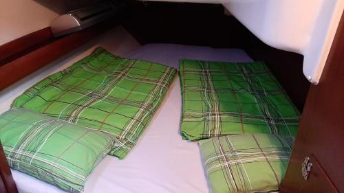 two green plaid pillows sitting on top of a bed at Velier Baby Two in Constanţa