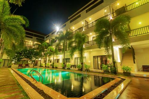 hotel z basenem przed budynkiem w obiekcie New Riverside Hotel w Siem Reap