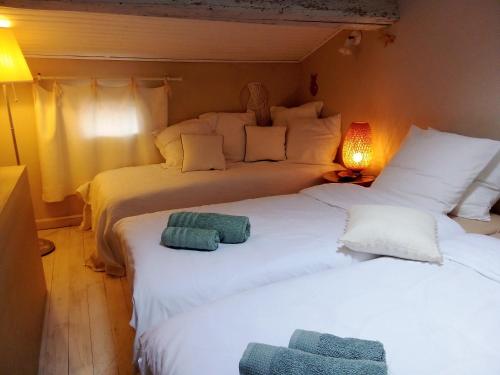 2 camas en una habitación con 2 camas blancas en La maison perchée, en Aigues-Mortes