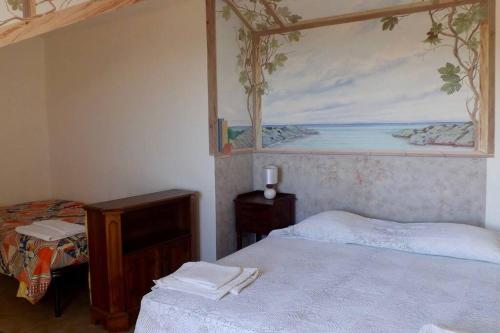 a bedroom with two beds and a painting on the wall at Casa Solemar in Imperia
