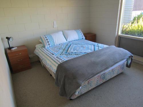 een kleine slaapkamer met een bed en een raam bij Little Ray of Sunshines by the Sea in Edithburgh