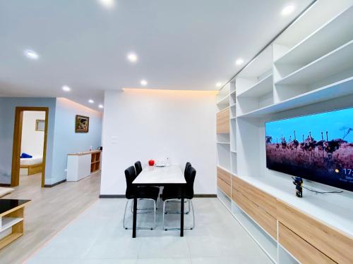 a dining room with a table and a flat screen tv at Muong Thanh Luxury Apartment Seaview in Danang