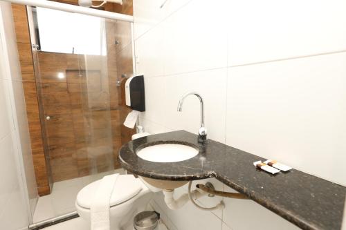 a bathroom with a sink and a toilet at Pousada Capital das Águas in Maceió