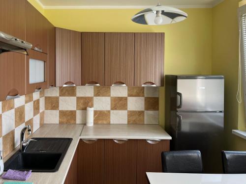 a kitchen with a sink and a refrigerator at Elegant Escape apartment - free parking, easy access to City Centre in Bratislava