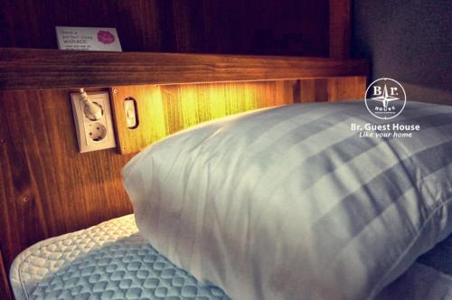 a bedroom with a bed with a wooden head board at Br. Guesthouse Hongdae in Seoul