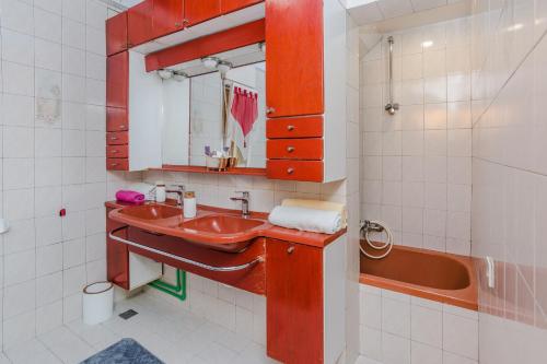 W łazience znajduje się czerwona umywalka i wanna. w obiekcie Naomi w mieście Zadar