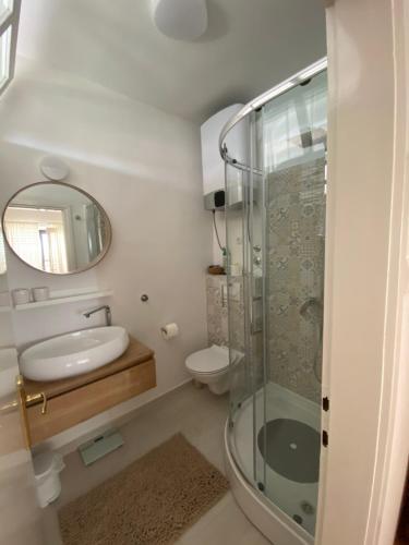 a bathroom with a shower and a sink and a mirror at Apartments Lorenandreja in Rab