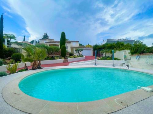 une grande piscine bleue dans une cour dans l'établissement Maison de vacances vue mer, à La Garonnette-Plage