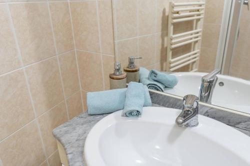 a bathroom with a white sink and a mirror at la petit maisonette de manu in Cannes