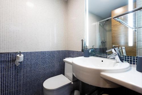 La salle de bains est pourvue d'un lavabo blanc et de toilettes. dans l'établissement Loft by Basquelidays, à Fontarrabie