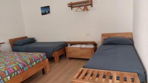a room with two beds and a table at Agriturismo Fiordimelo-Camere in Tirano