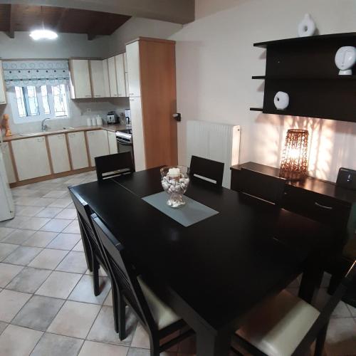 a dining room with a black table and chairs at Luxury Beach Villa in Skála