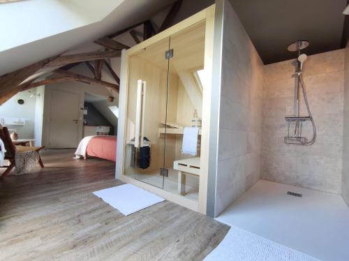 Saint-Ouen-des-ToitsにあるLa Douce Halte - Gîtes avec Spa ou Saunaの屋根裏のバスルーム(ガラス張りのシャワー付)