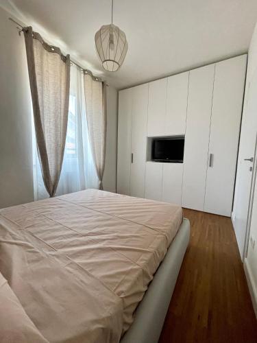ein weißes Schlafzimmer mit einem großen Bett und einem TV in der Unterkunft Casa Laura in Pieve a Nievole