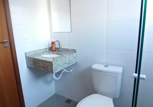 a bathroom with a white toilet and a sink at Casa Aconchego in Socorro