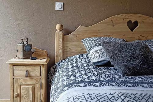 une chambre avec un lit et une horloge sur une table de nuit dans l'établissement LA GRANGE SAVOYARDE-Spa-Piscine-Proche lac-Charme-Détente- 3 Etoiles, à Lathuile