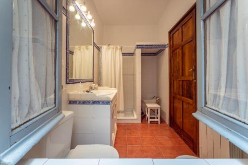 a bathroom with a sink and a toilet and a mirror at Casa Rural con piscina- Tierra de Barros 